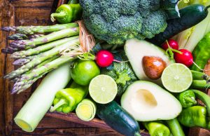 Organic vegetables on rustic dark wood background.Vegan food concept. Green veggies.
