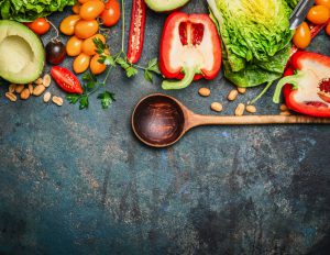 Colorful organic vegetables with wooden spoon , ingredients for salad or filling on rustic wooden background, top view. Healthy food or diet cooking concept.